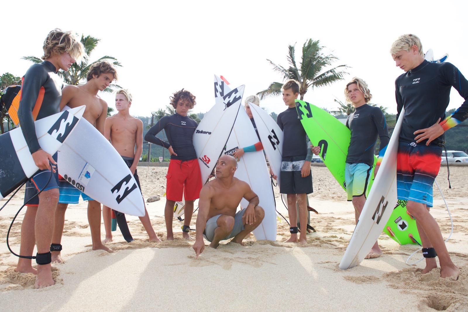 Rainos coaching a group of young surfers on the beach